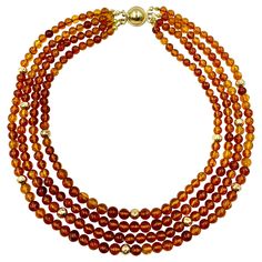 Early 20th Century round natural honey colored 5-6mm amber and hammered 5mm gold bead necklace composed of four strands. The amber beads lively, ranging in color from a golden yellow to light orange honey color with natural inclusions, slightly varied indicating being hand made. Clasp marked 14K and signed with a script capital H Excellent condition Zelda Au, Orange Honey, 1st Dibs, Coral Beads Necklace, Honey Color, Rose Gold Pearl, Gold Topaz, Rose Gold Beads, White Pearl Necklace