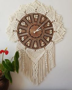 a wall clock that is on the side of a wall next to a potted plant