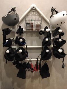 a group of black and white hats hanging on a wall next to a wire rack