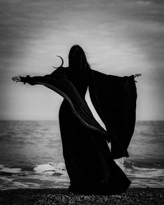 a woman standing on top of a beach next to the ocean