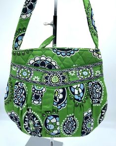 Vera Bradley Hannah Purse in Cupcakes Green Retired in 2009 by Vera Bradley, this iconic pattern is in a beautiful shade of green, with blues and white accents.  The cotton lining is in a coordinating pattern.  Signature zipper pulls are green. Features: Zip closure with signature Vera Bradley zipper pulls oval shaped base 2 Interior slip pockets lightweight top handle signature Vera Bradley seam tag Dimensions: 9" X 8" X 2.5" with top handle drop of 6.5" Condition:  Excellent Previously Owned w Cupcakes Green, Coordinating Patterns, Small Handbag, Lightweight Tops, White Accents, Zipper Pulls, Small Handbags, Shades Of Green, Vera Bradley