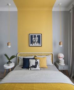 a bedroom with yellow and gray walls, white bedding, and pictures on the wall