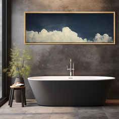 a bath tub sitting next to a window with a painting on the wall above it