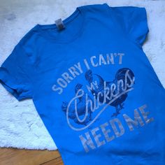 This Tee Shirt Had Me At “My Chickens Need Me”. For All The Chicken Parents Out There, Both Farm And Suburbs Alike, This One’s For You. In Nwot Euc Like New Condition, A Teal Or Turquoise Blue Tee Shirt (My Camera Makes The Color Appear Darker Than It Actually Is) In A Size Small. 100% Cotton. The Font Is Silver And The Very Detailed Illustrations Of Chickens In Back Are A Black Or Very Dark Blue Color. You Can See Feathers And The Eyes On The Faces Of The Chickens. This Gildan Tee Is A Heavy Cotton, Like The Label Says. Measures Pit To Pit 16.5” Length 26.5” Casual Silver Tops With Graphic Print, Casual Silver Top With Graphic Print, Silver Short Sleeve Graphic Tee, Silver Graphic Print Cotton Top, Silver Cotton Top With Graphic Print, Silver Cotton Tops With Graphic Print, Blue Tee, Dark Blue Color, The Chicken