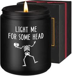 a black candle with a skeleton holding a skull and the words light me for some head on it