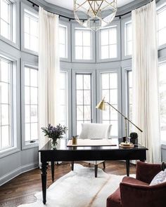 a living room filled with furniture and large windows