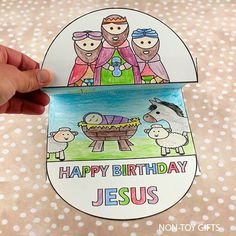 a hand holding up a paper cutout with the words happy birthday jesus on it