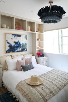 a bedroom with a bed, dresser and hat on it