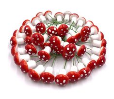 red and white mushrooms are arranged in a circle on top of each other, with green stems sticking out of them