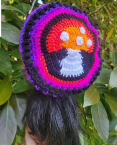 a woman wearing a crocheted hat with an eagle on it's side