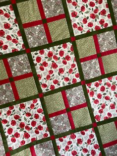 a red and green quilt with flowers on it