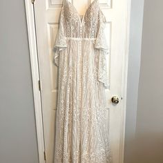 a white dress hanging on a door with a hanger in front of the door