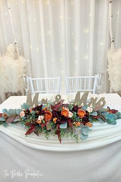 the table is decorated with flowers and mr and mrs signs on it's sides