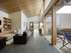 a living room filled with furniture and a flat screen tv on top of a wooden wall