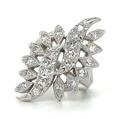 a white gold ring with diamonds in the center and leaves on it's side