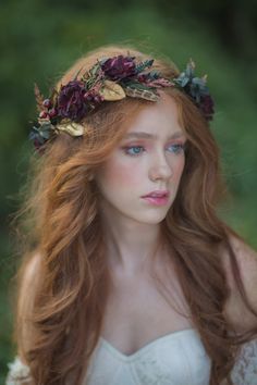 a woman with long red hair wearing a flower crown