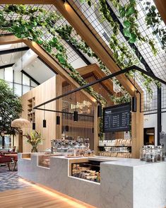 the interior of a restaurant with wooden floors and plants growing on the wall above it