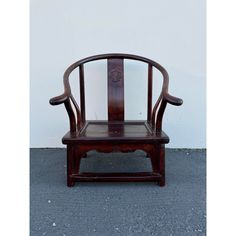 an old wooden chair sitting in front of a white wall