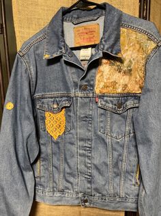 a denim jacket with patches on it sitting on a chair