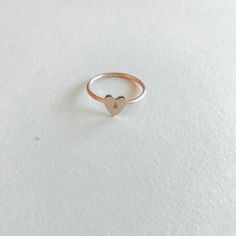 Make a sentimental statement with this custom ring. The heart pendant is so pretty and is a romantic addition to your ring stack. Choose up to three characters to show your love with our Heart Keepsake Ring. Materials: 14k Gold Fill, 14k Rose Gold Fill, Sterling Silver Measurements: .25” Heart Charm Rose Gold Promise Jewelry For Valentine's Day, Rose Gold Stackable Midi Rings For Promise, Elegant Stackable Rings With Heart Charm For Gift, 14k Rose Gold Heart Ring For Valentine's Day, Stackable Rose Gold Heart Ring Fine Jewelry, Minimalist 14k Rose Gold Heart Ring, Rose Gold Stackable Heart Ring In Fine Jewelry Style, Dainty Rose Gold Initial Ring, Rose Gold Open Heart Jewelry For Wedding