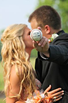 a man and woman kissing each other while holding a ball