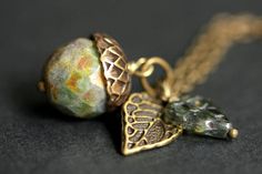 A handmade acorn necklace designed from a rainforest green glass crystal with a hint of mottled brown accents that has been combined with a detailed bronze leaf and green Czech glass leaf charm. If you would like a length of chain different than offered, please contact me for pricing. Check out the other colors if acorn necklaces offered in my shop! http://etsy.me/1iMZM8w Stop by and visit http://stumblingonsainthood.etsy.com to see more handmade designs! © Stumbling On Sainthood (StumblingOnSai Secret Message Locket, Acorn Jewelry, Oak Leaf Necklace, Acorn Pendant, Bronze Green, Acorn Necklace, Feminine Jewelry, Nature Inspired Jewelry, Leaf Charms