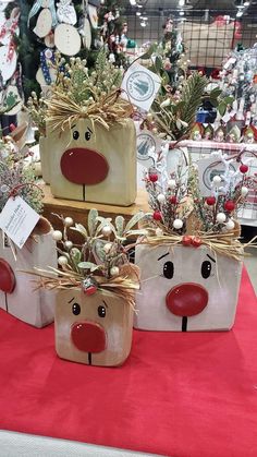 three reindeer planters sitting on top of a red table