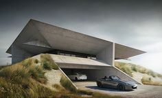 a car is parked in front of a building with grass on the ground and sand dunes behind it