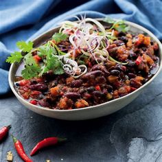 a bowl filled with beans, onions and cilantro on top of a blue cloth