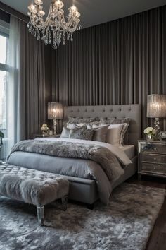 a bedroom with a large bed and chandelier