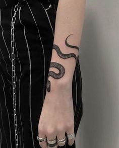 a woman with a snake tattoo on her left arm and two rings around her wrist