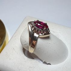 This Bright Ring Features A 8x4mm Marquise Cut Lab Ruby, Set With 4 Secure Prongs On A Halo Head. There Are 14 Natural Round White Diamonds Forming The Halo Around The Ruby. The Setting Is High Polished With A Step Down Offset Design, Aprox 1/2" In Width At The Center And Weighs Aprox 2.498 Grams Of Solid (Stamped 10kt & Gtr) 10kt Yellow Gold. This Bright Lab Ruby & Diamond Ring Has A Msrp Of $2819.00. Finger Size 7 (This Ring Can Be Sized By Your Local Jeweler, At Your Cost, We Do Not Size) Classic Marquise Ruby Ring With Vvs Clarity, Classic Marquise Ruby Ring With Brilliant Cut, Classic Pear-shaped Ruby Ring With Prong Setting, Pear-shaped Brilliant Cut Yellow Gold Ruby Ring, Classic Pear-shaped Ruby Ring With Center Stone, Classic Ruby Jewelry With Marquise Cut, Marquise Cut Ruby Jewelry In Yellow Gold, Classic Marquise Cut Ruby Jewelry, Yellow Gold Marquise Cut Ruby Jewelry