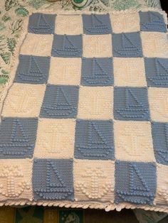 a blue and white crocheted blanket sitting on top of a table