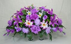 purple and white flowers are arranged in an arrangement