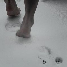 a person walking in the snow with their bare feet