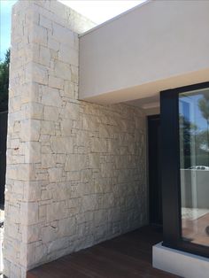 an outside view of a house with wood flooring and stone walls, including the front door