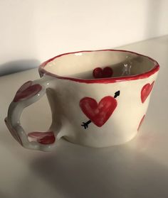 a ceramic cup with hearts painted on it