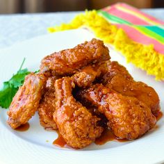 a white plate topped with chicken wings covered in sauce