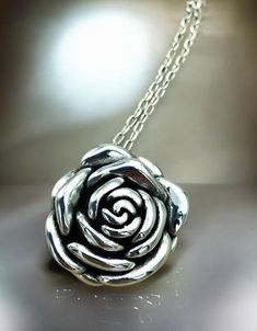 Elevate your jewelry collection with our exquisite Rose Flower Pendant Necklace, masterfully crafted from premium 925 Sterling Silver. This hollow-formed pendant showcases an intricate rose design, offering an elegant and timeless aesthetic. The pendant dimensions are a tasteful 1 inch by 1 inch, perfect for making a subtle yet impactful statement. For a harmonious look, you have the option to pair the pendant with a matching 18-inch cable link necklace, also fashioned from high-quality 925 Ster Elegant Silver Necklace With Rose Design, Classic Rose Design Jewelry For Anniversary, Sterling Silver Rose Flower Jewelry, Rose Sterling Silver Jewelry For Valentine's Day, Silver Rose Design Necklace For Anniversary, Silver Rose Design Jewelry For Formal Occasions, Classic Rose Jewelry For Anniversary, Silver Rose Detail Sterling Silver Jewelry, Silver Flower Pendant Jewelry For Anniversary Gift