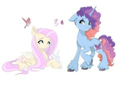 two ponies sitting next to each other on top of a white surface with butterflies flying around