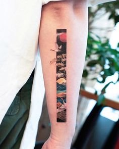 a person with a tattoo on their arm that has an image of mountains in it