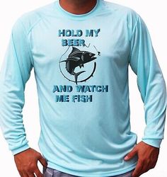 a man wearing a blue long sleeved shirt that says hold my beer and watch me fish