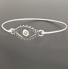 "Evil Eye Bracelet - Evil Eye Jewelry A detailed silver tone evil eye charm will be transformed into a beautiful evil eye bracelet with bangle band choice of silver filled or sterling silver. Also available with a gold tone evil eye and bangle band choice of brass or 14k gold filled band. If you want this option for your evil eye bracelet bangle, select from options when ordering. This evil eye bracelet looks great stacked with other bangles from my collection as you can see from the last 4th pi Metal Evil Eye Bracelet, Silver Metal Evil Eye Bracelet As Gift, Adjustable Silver Bohemian Evil Eye Bracelet, Silver Evil Eye Bracelet Spiritual Style, Silver Spiritual Bracelet With Evil Eye, Spiritual Silver Bracelet With Evil Eye, Silver Bohemian Evil Eye Bracelet Gift, Bohemian Adjustable Eye-shaped Jewelry, Adjustable Bohemian Eye-shaped Jewelry