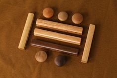 several wooden pegs are arranged on a brown surface next to some rocks and wood