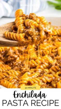 a wooden spoon full of pasta with sauce being poured over it and the words, enchilada pasta recipe