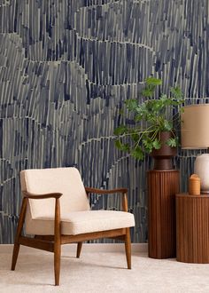 a chair and table in front of a wallpapered room with a potted plant