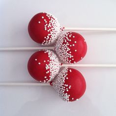 three red cake pops with white sprinkles are on top of each other