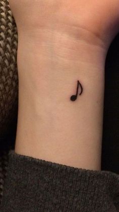 a small music note tattoo on the wrist