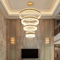 a large chandelier hangs from the ceiling above a tv in a living room