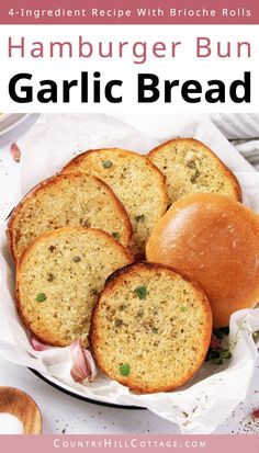 four hamburger buns sitting on top of a white plate with garlic bread in it